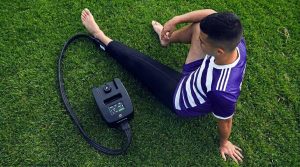 An athlete using the Cryon-X Pro cold compression unit on their leg for post-workout recovery.